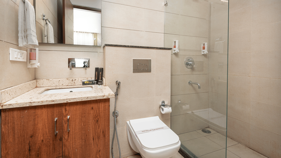 A deluxe room washroom featuring a large mirror and neatly arranged toiletries at DLS The Classio